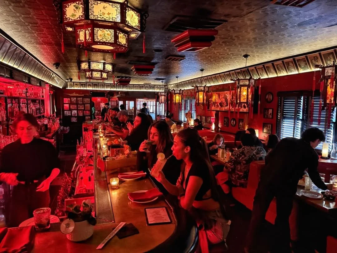 Patrons enjoying drinks at The Formosa Cafe’s red-lit cocktail bar, featuring vintage interiors and a lively evening crowd.