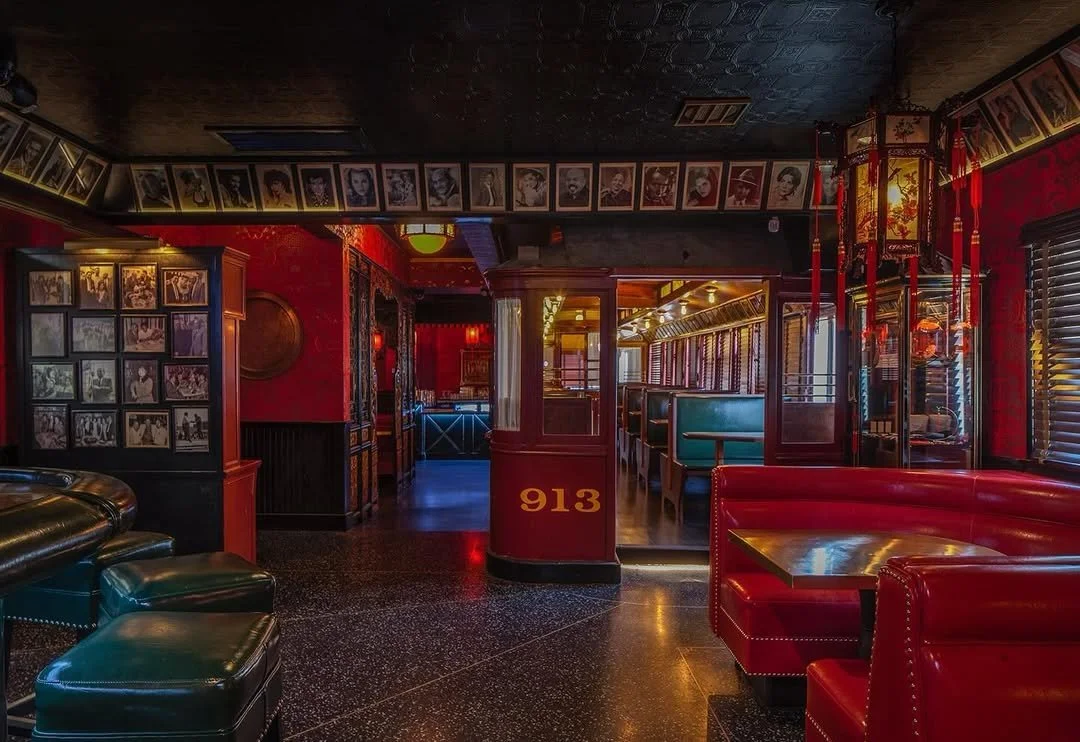 Vintage red booth seating inside The Formosa Cafe with framed Hollywood photos covering the walls.