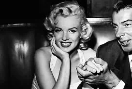 Black-and-white photo of Marilyn Monroe and Joe DiMaggio seated together in a booth at The Formosa Cafe.
