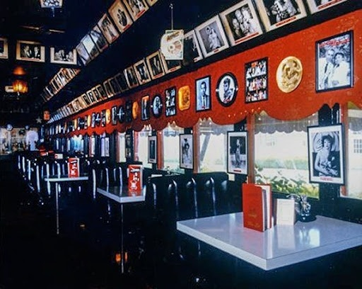 Gallery wall of framed black-and-white photographs showcasing classic Hollywood actors and entertainers inside The Formosa Cafe.
