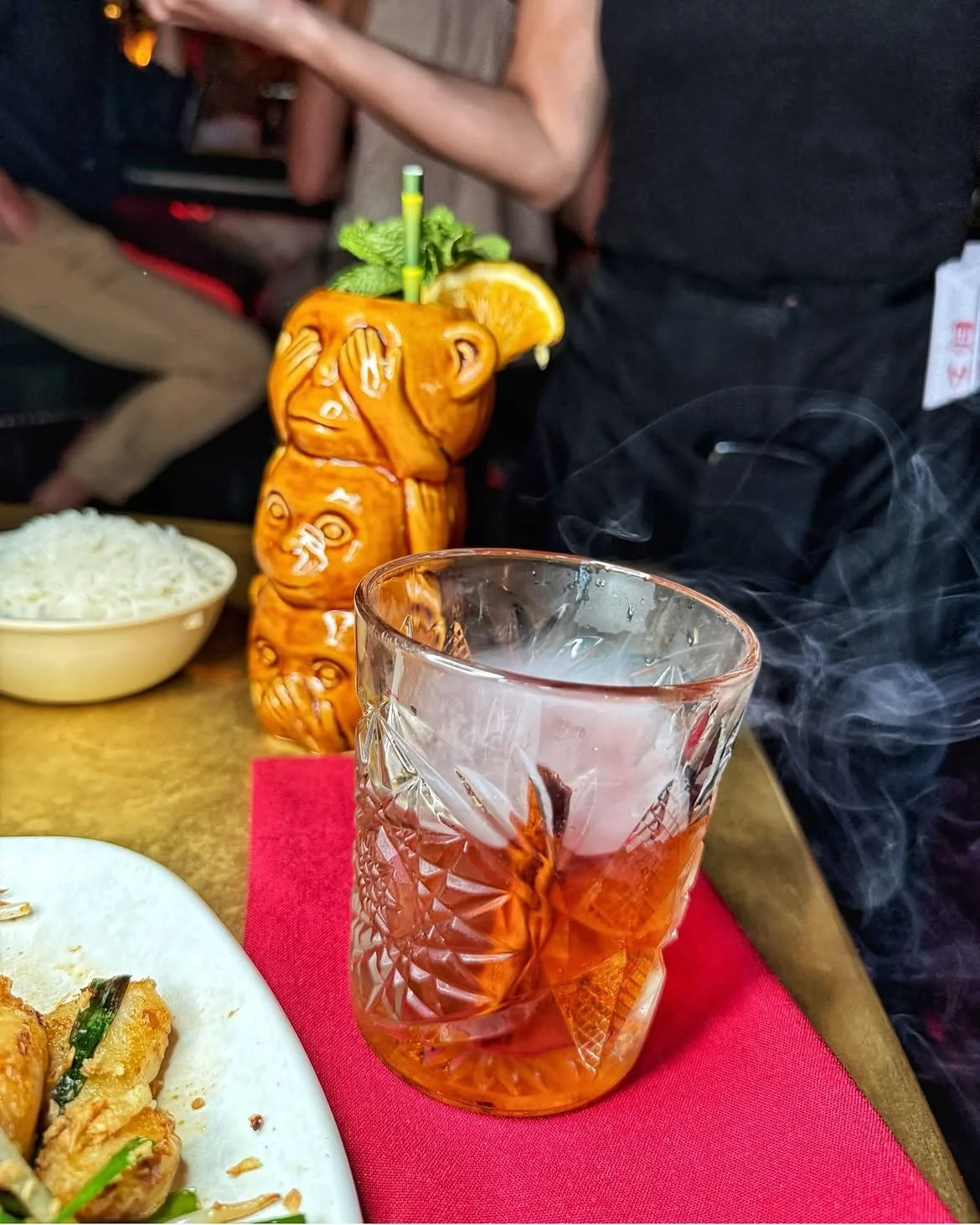 Smoking cocktail served beside a monkey-shaped tiki mug at the historic Formosa Cafe.