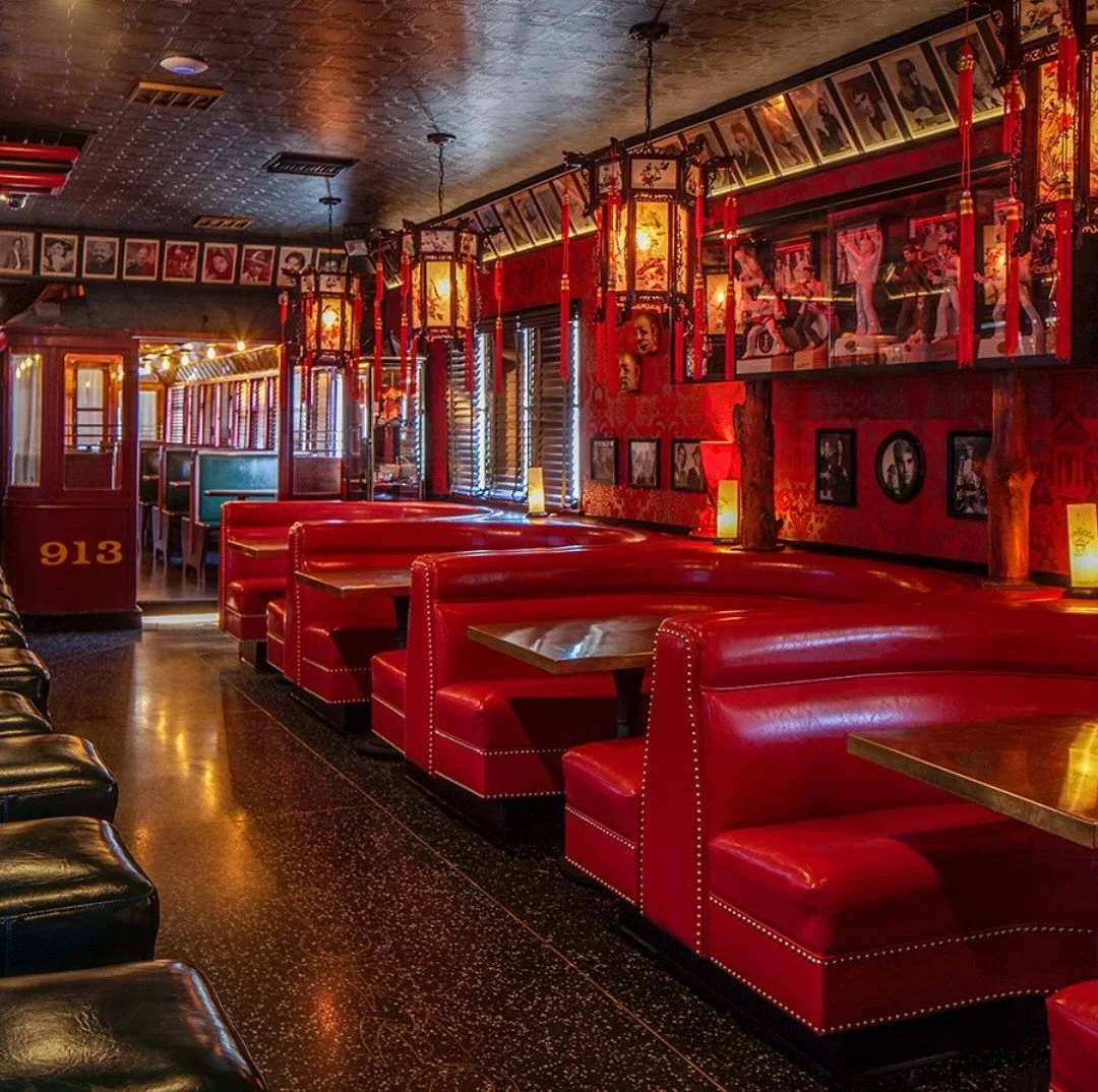 Red leather booths and vintage lanterns inside The Formosa Cafe dining room.