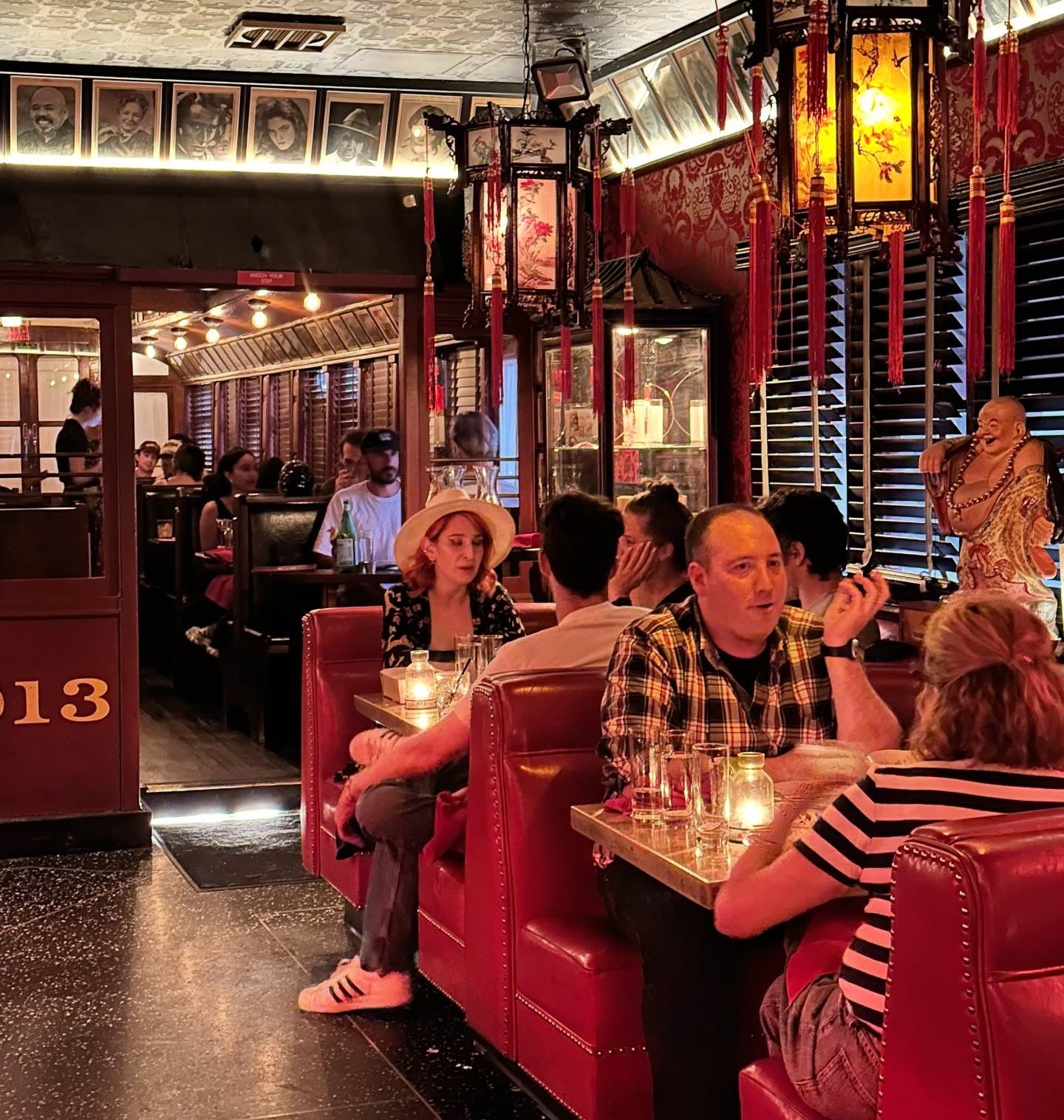 Cozy interior of The Formosa Cafe with red booths, lantern lighting, and diners enjoying Chinese food.