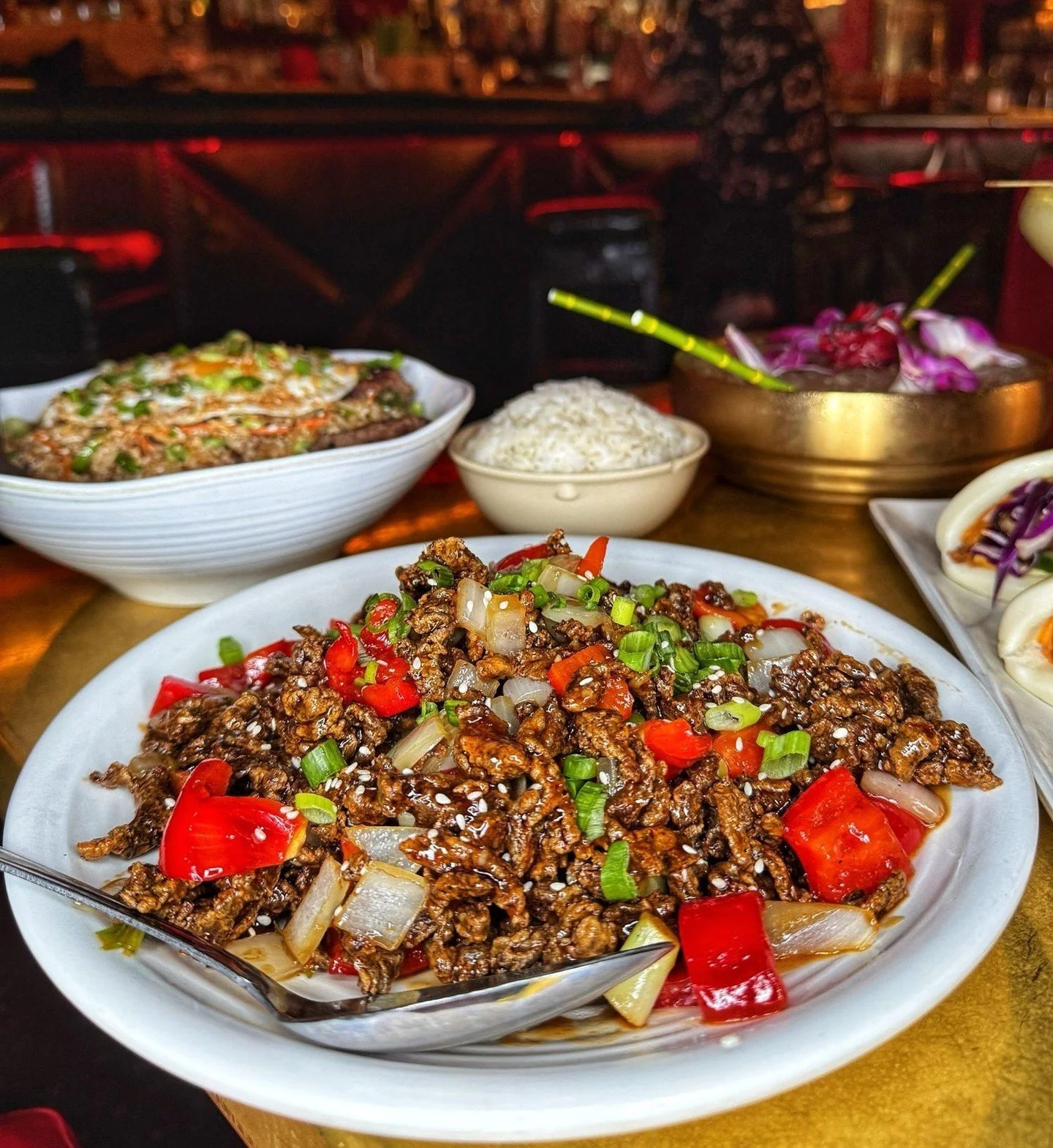 Savory Asian fusion dishes, including stir-fried beef and rice on a table at The Formosa Cafe in West Hollywood.
