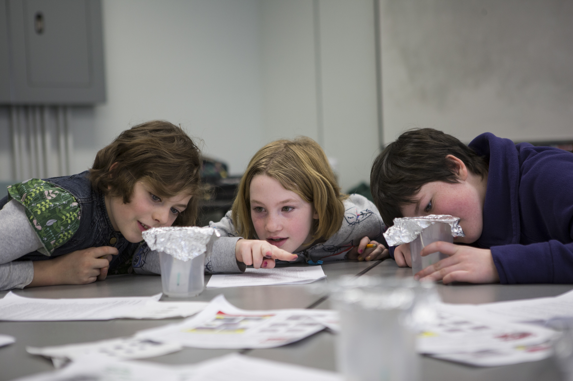  From left to right: Emma DeCicco, Brianna Jecklin and Charlie Fox use chromatography to compare the distance wet ink from two separate markers travels to determine which marker might have been used in a "ransom" note.  