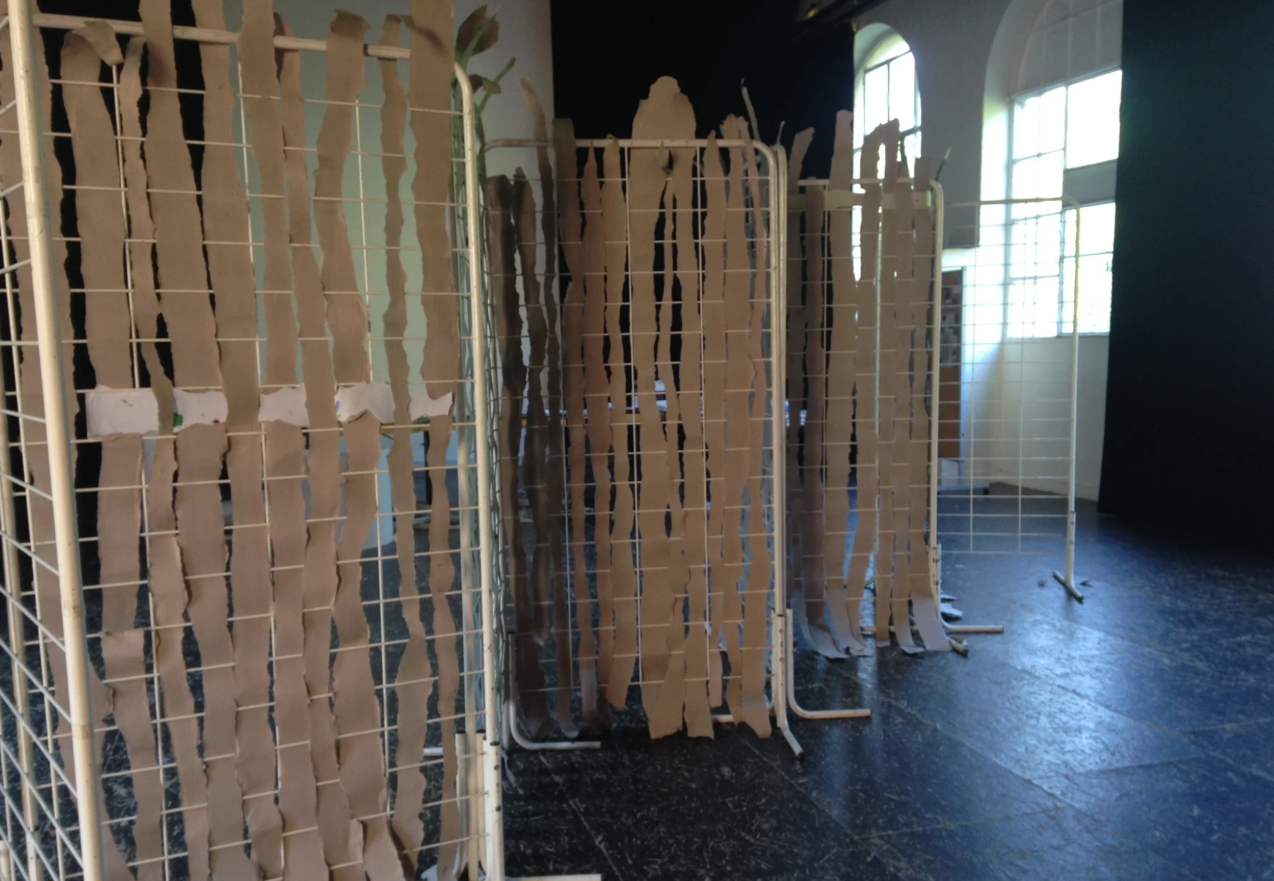The warped grid of the concertina artist book installed on the floor in the afternoon light.
