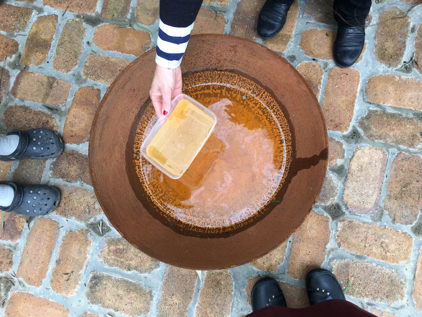 Draining water from the rusted fire pit with its amazing mandala pattern.