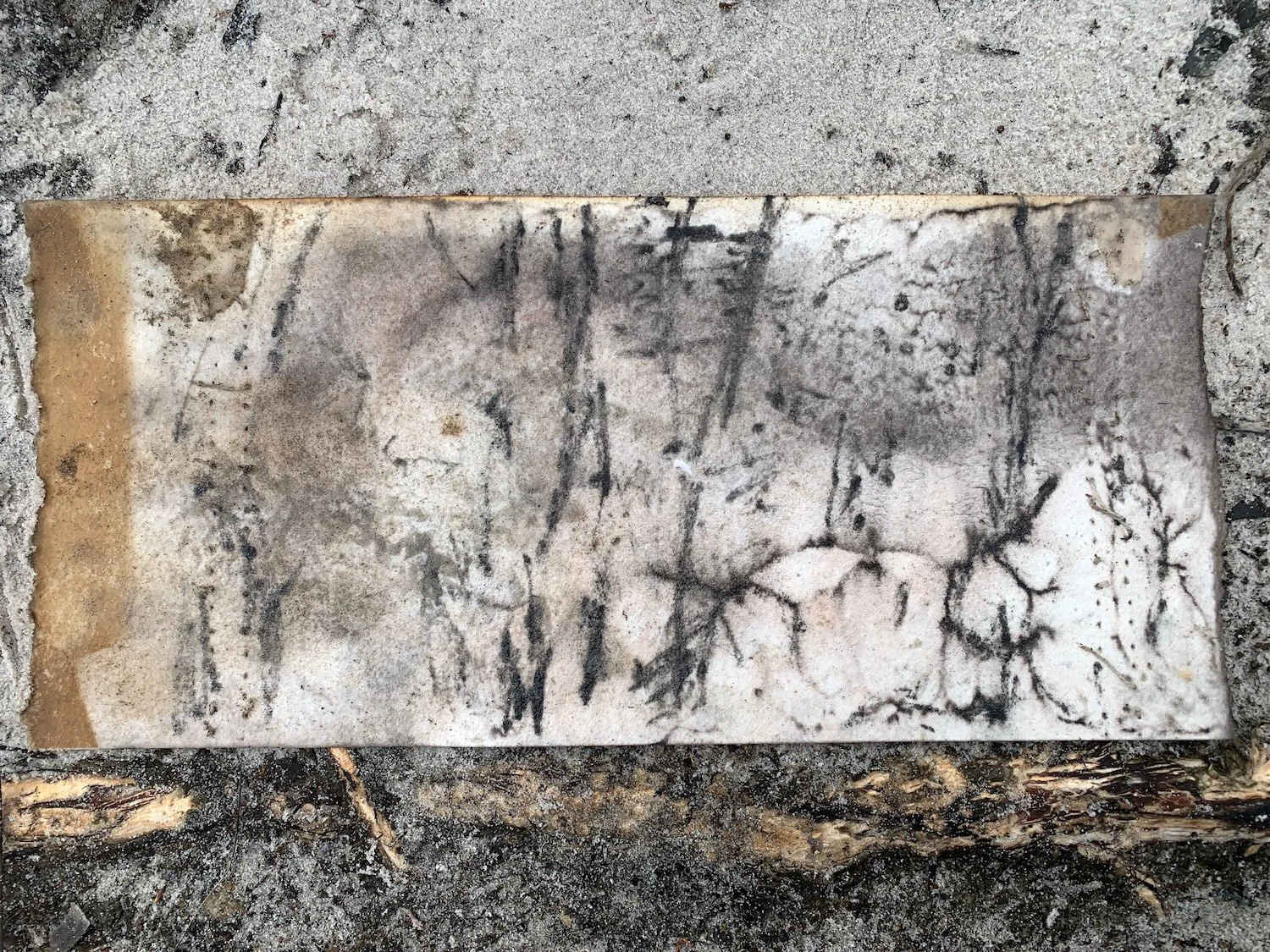 Sand and charcoal marks on paper