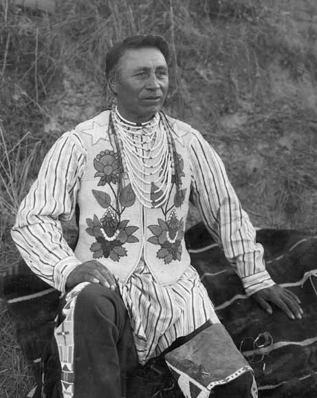 Photograph of man wearing traditional Salish dress by unknown photographer.