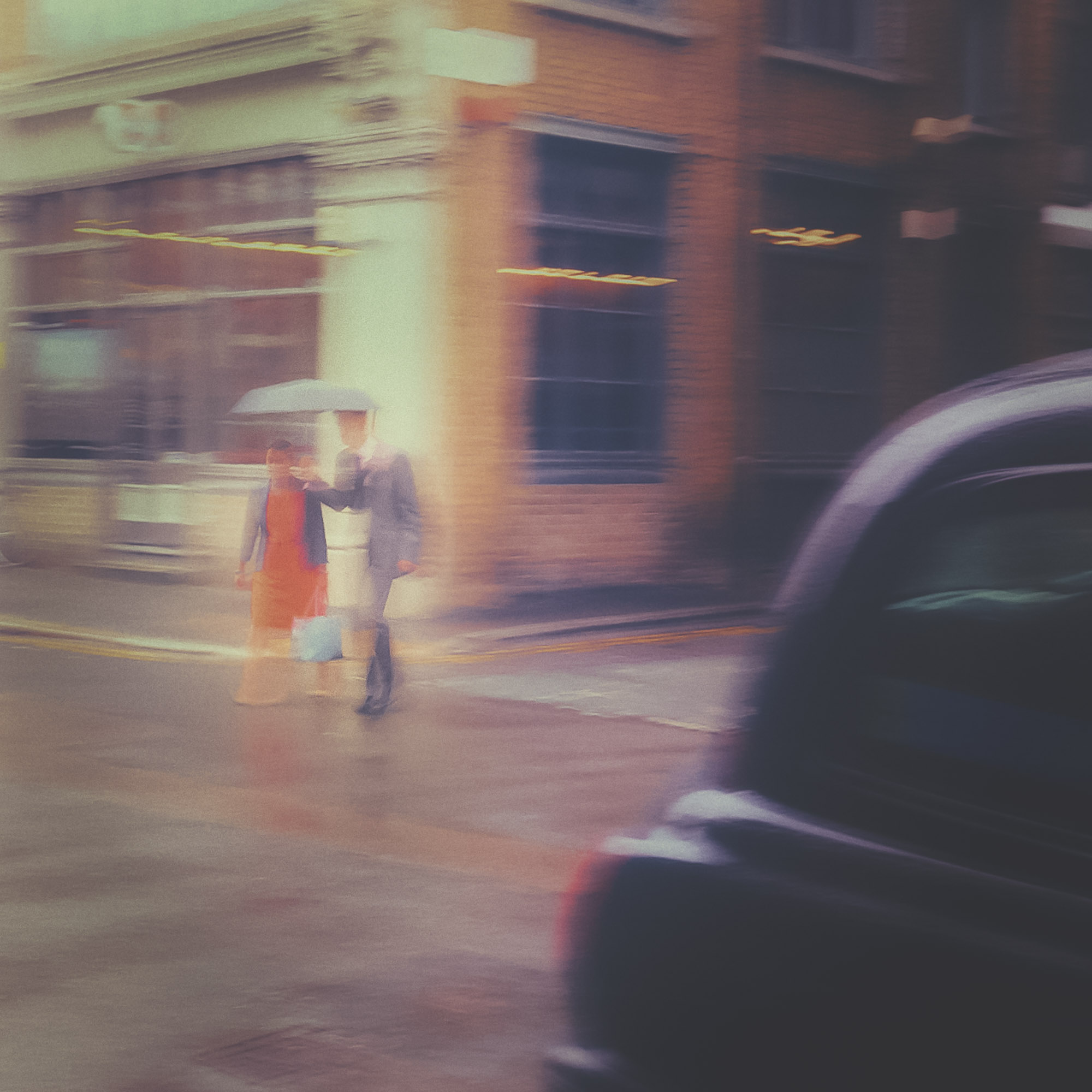 Black cab. A couple is seen walking on the streets of London during a rain day.