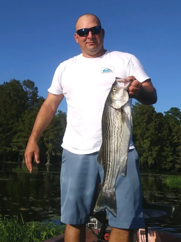 Photo: Ernie Martin Henry Rockwell holds up a striped bass he caught on Lake Talquin.