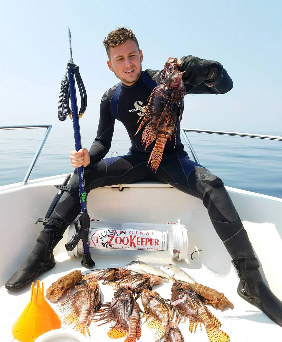 With a ZooKeeper lionfish containment unit by his side, lionfish hunter Tristan Lennard shows off his haul from a recent dive – including this personal best 17-inch fish.