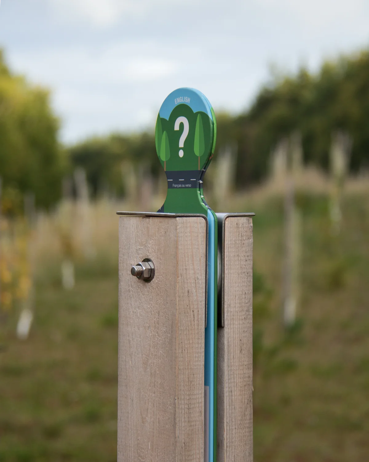 A SIMPLE MARKER Wooden posts adorned with a simple graphic element indicate locations of interpretive content.