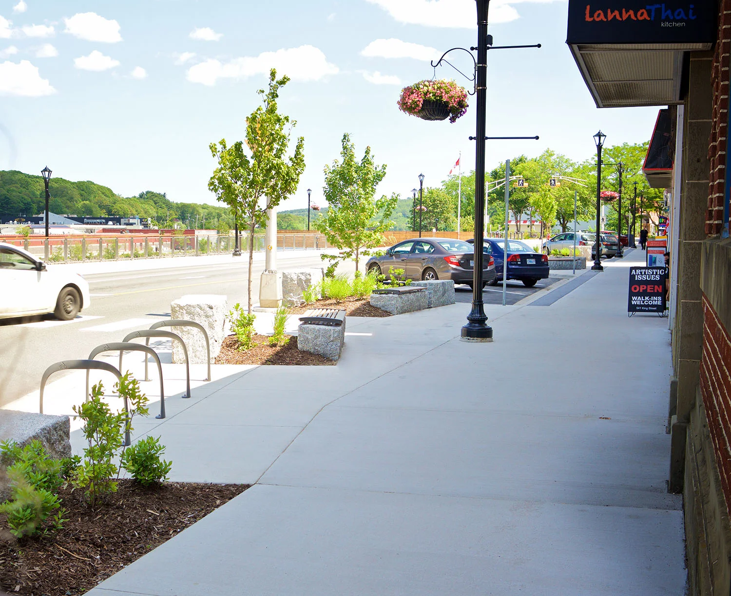 Trees soften the streetscape and provide shade for the granite benches that provide seating along the storefronts.