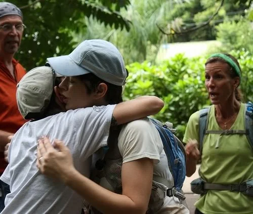 Hugging Sarah at the start of loop 5. Poor Sarah: I cannot even imagine how stinky I must have been! That's Sue on the right, being a perfect pacer, urging me to get goin' on loop 5. Photo by Andrea Stout.