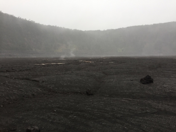 Steam rising from the crater's surface cracks.