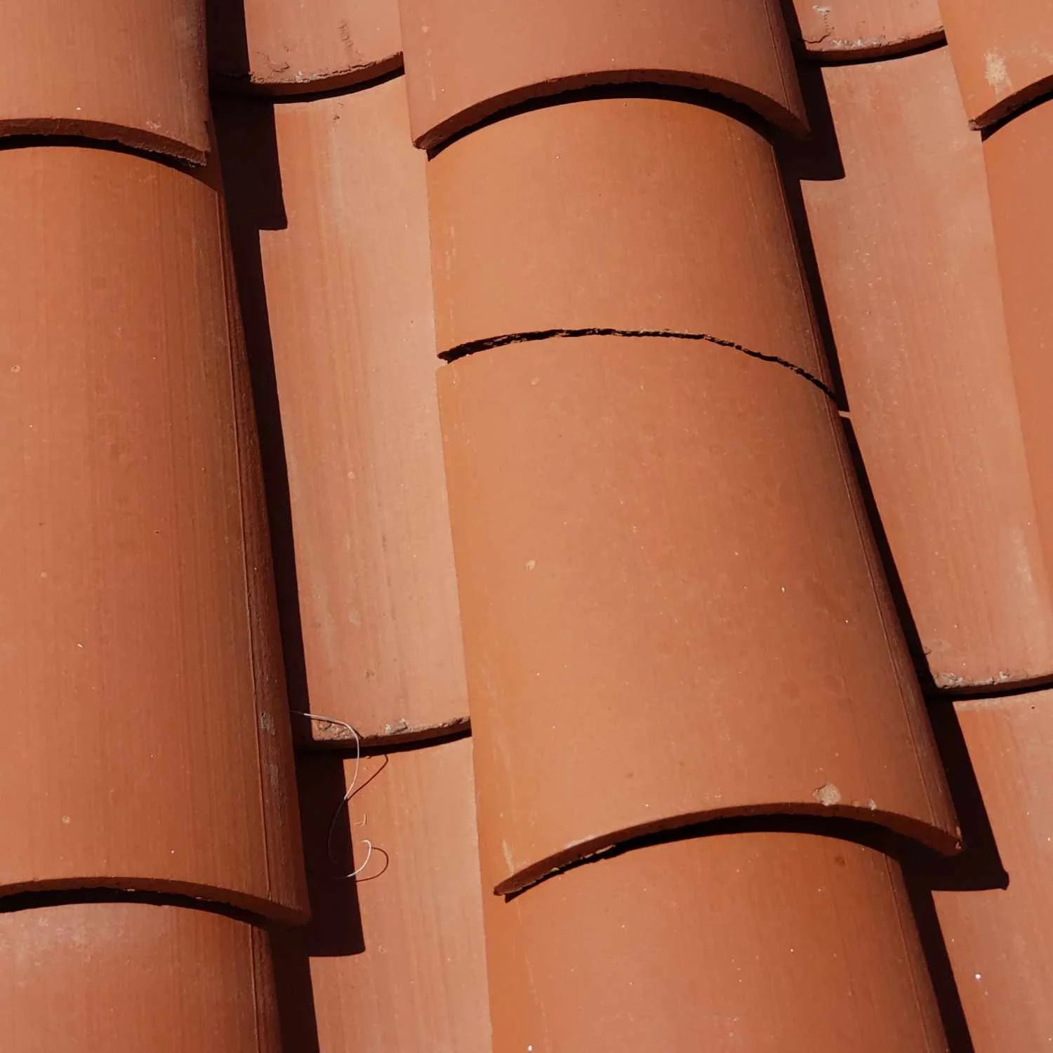 Cracked terra cotta roof tile identified during final walkthrough inspection of new construction home.