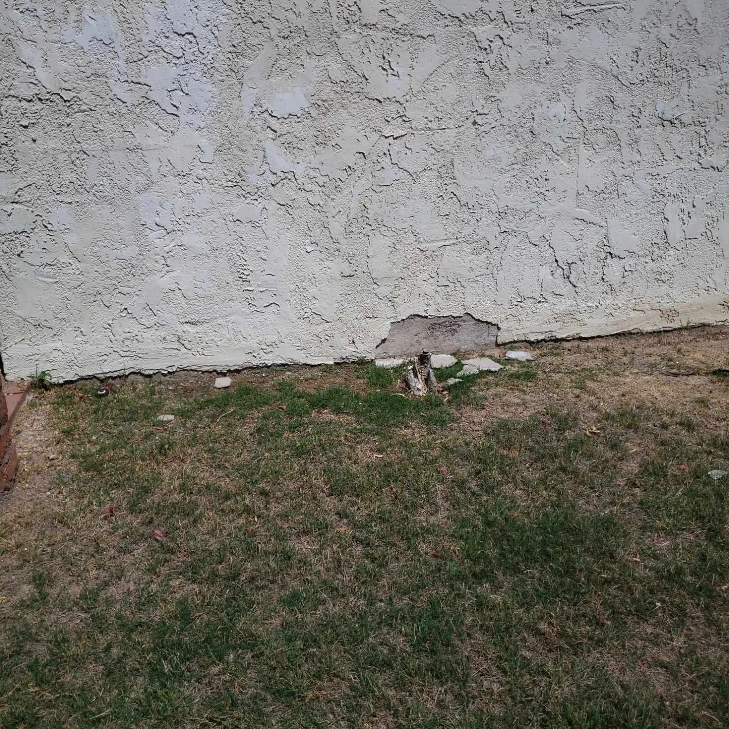 Chipped and cracked stucco on exterior wall of a home during construction inspection in Arizona.
