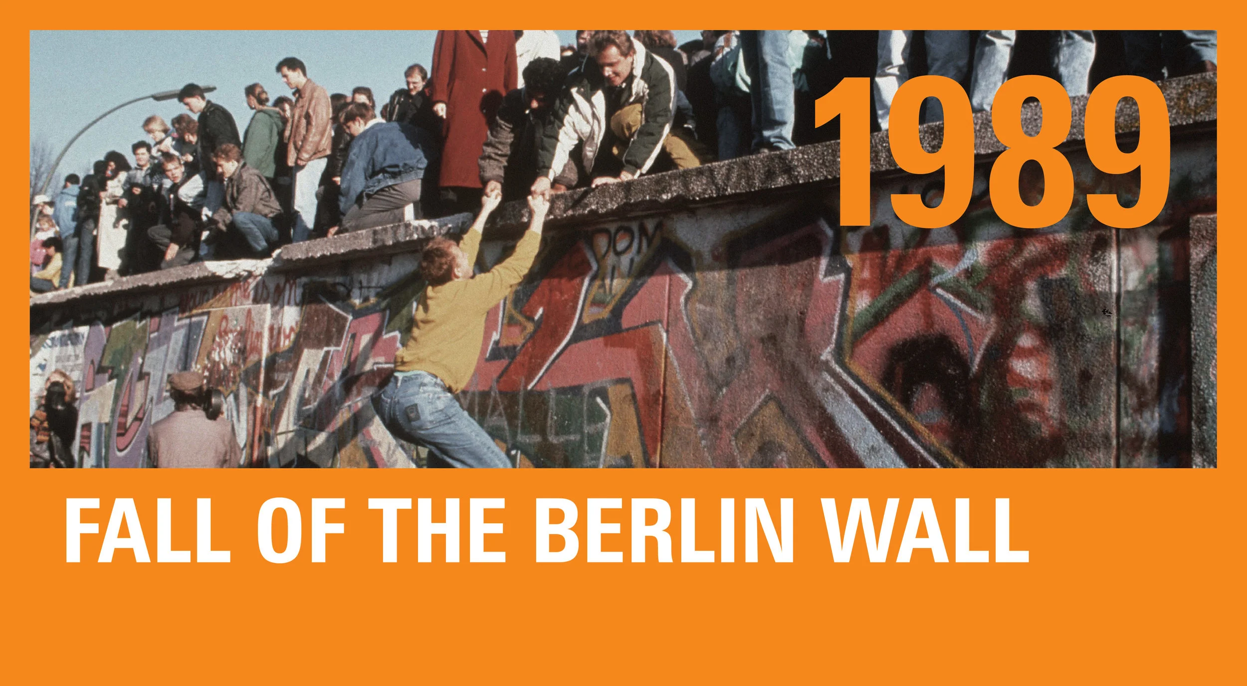 Giddy Germans climb the Berlin Wall after its opening on November 9.