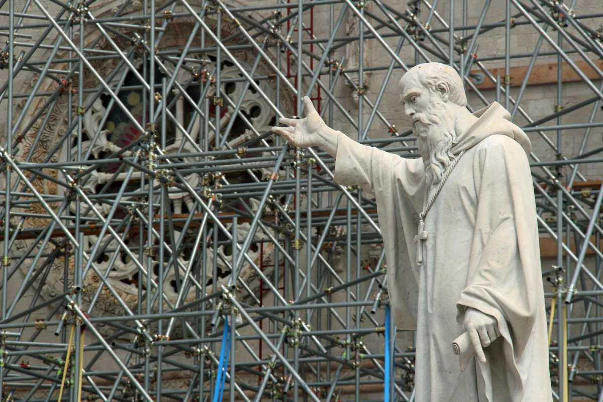 St. Benedict standing before the basilica's rose window