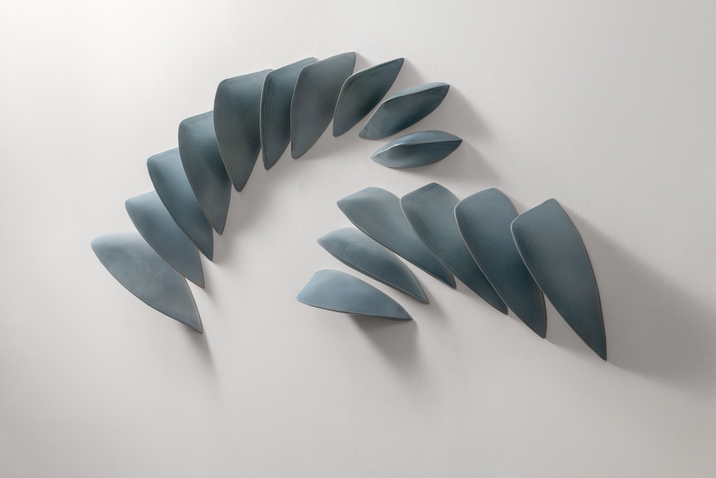  Maren Kloppmann (German, born 1962)   Helical Wave Skyblue , 2026 Hand-built glazed porcelain, 16 elements 71 w x 9.25 d x 32 h inches  Photo: Eric Mueller 