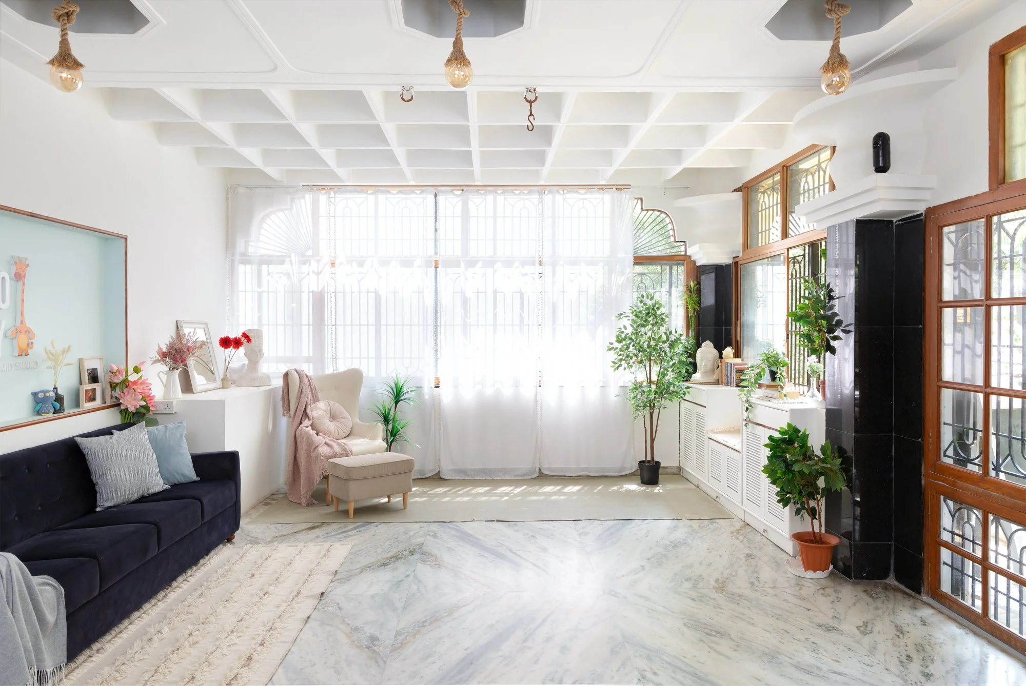 All-white natural light photography zone at Studio Flinto Bangalore with a French-style wall and large windows.