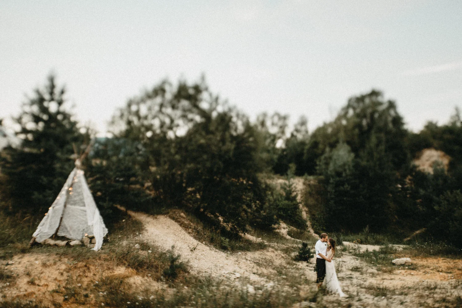 boho setup, bride and groom next to a tent