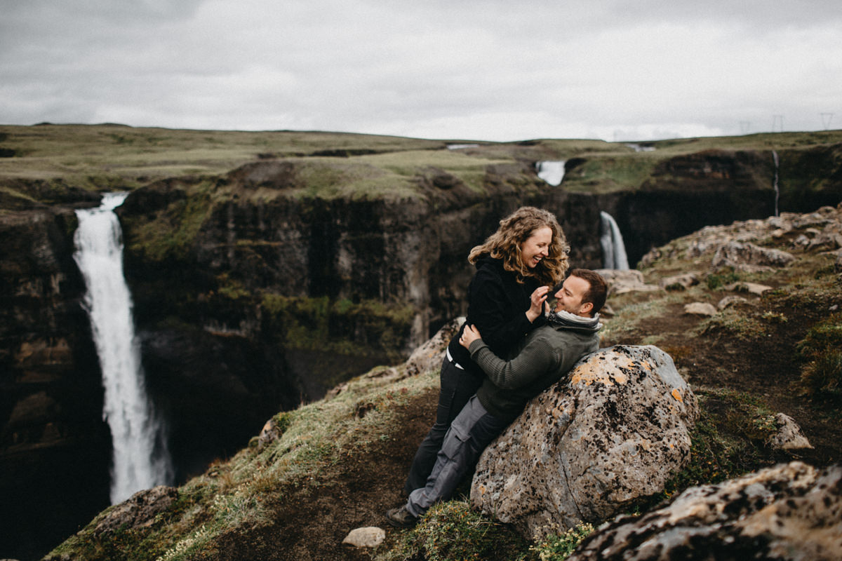 couple hugging in front of a waterfall