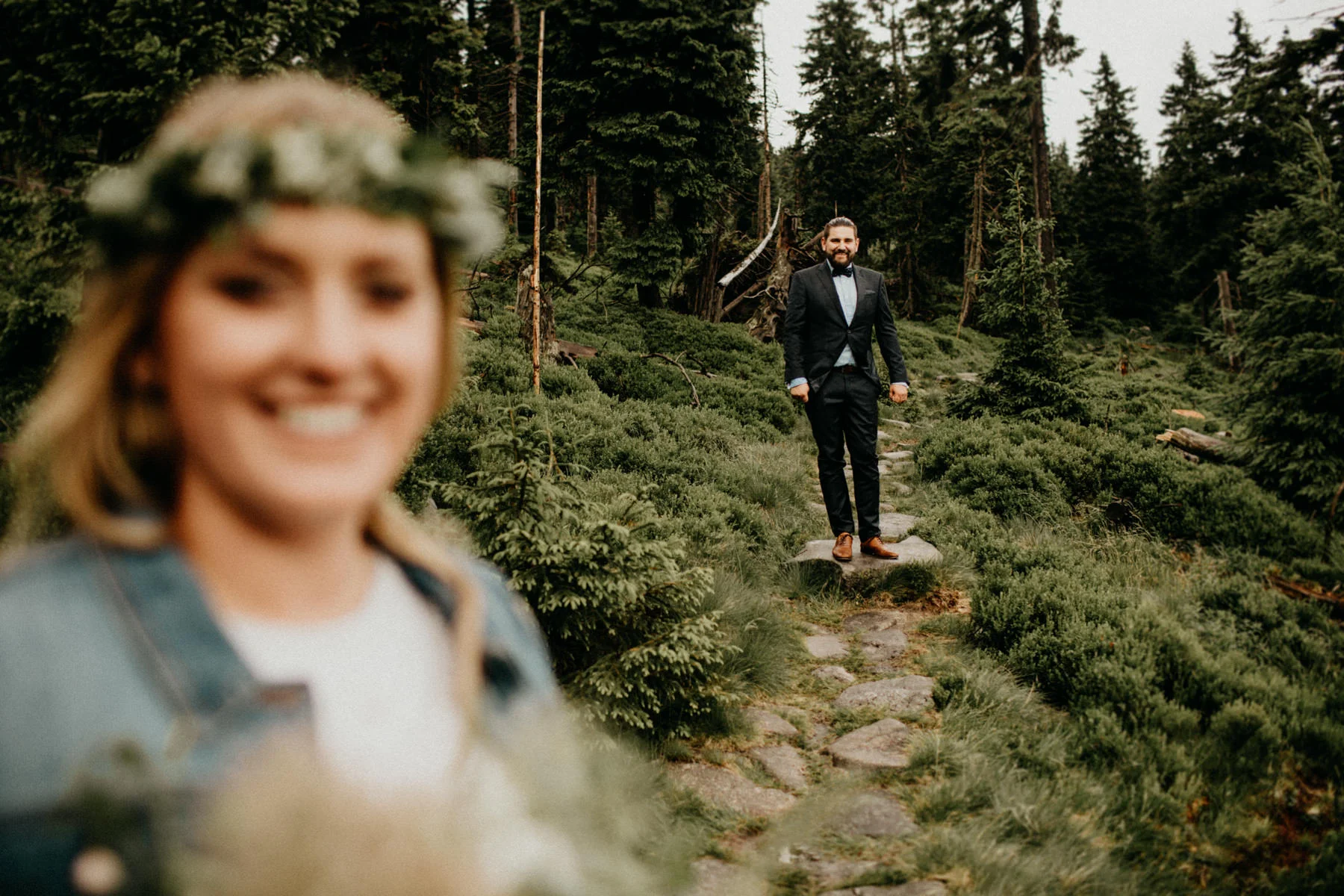 groom looking at his bride in the forest
