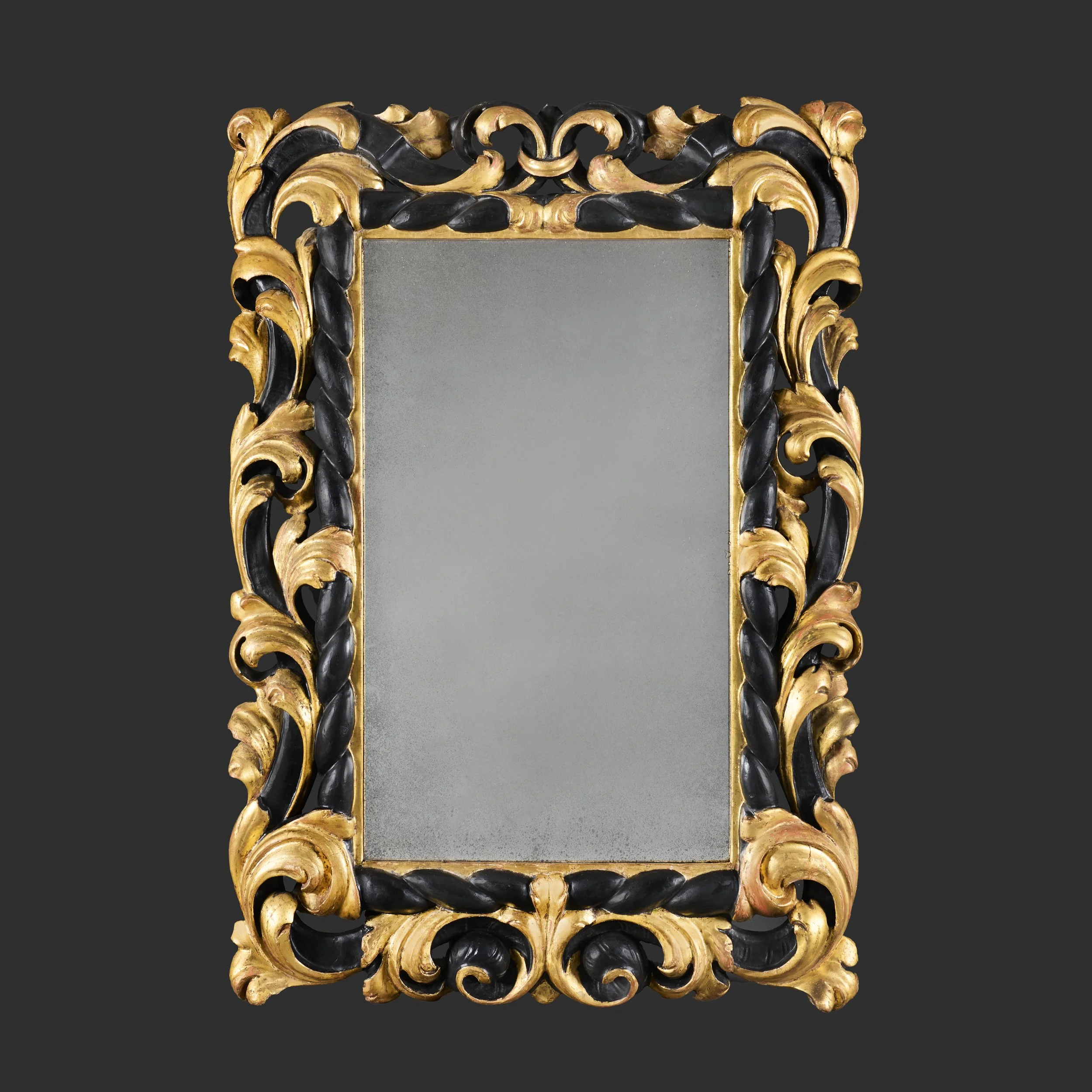 A TUSCAN GILTWOOD AND EBONISED MIRROR
