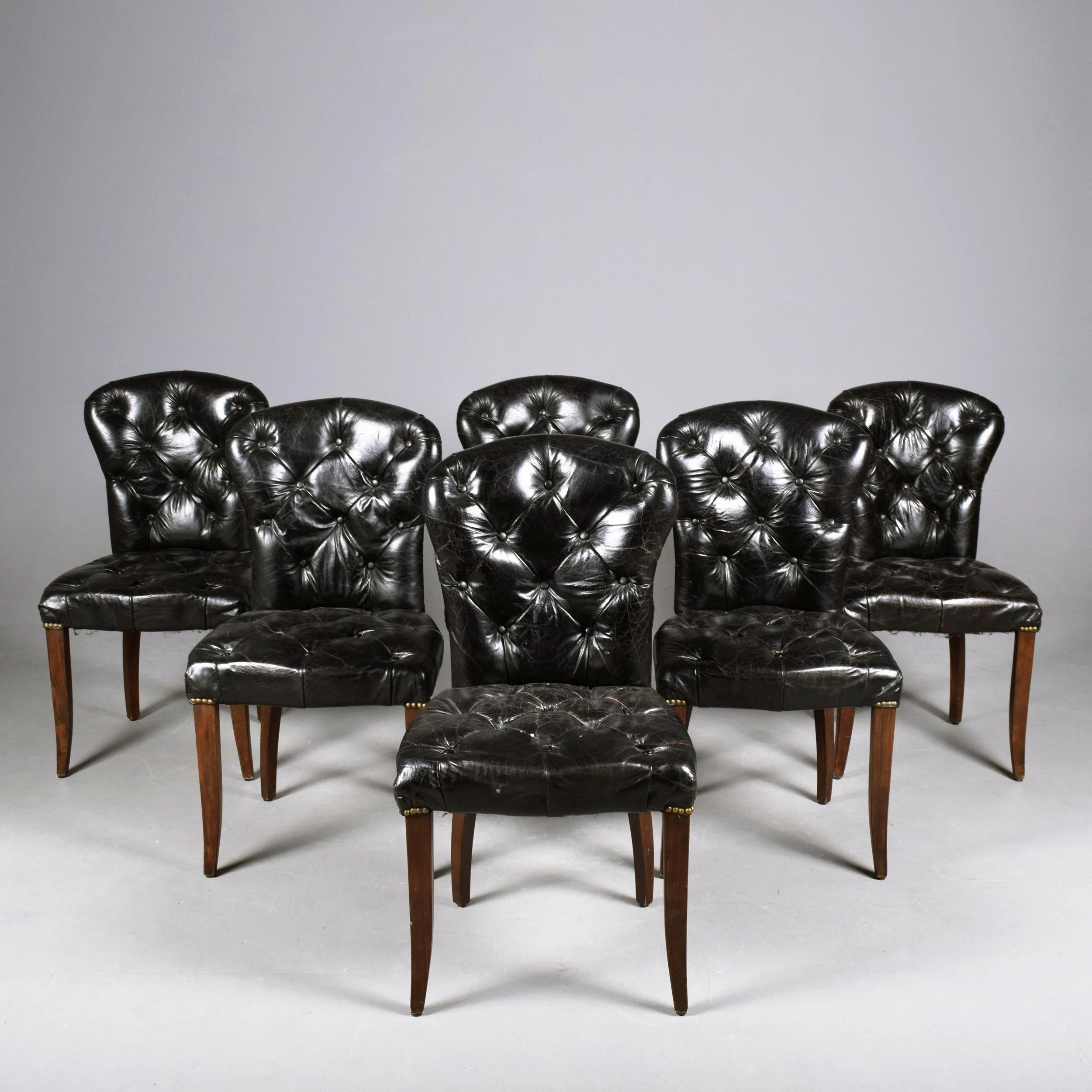 A SET OF SIX DEEP BUTTONED BLACK LEATHER DINING CHAIRS