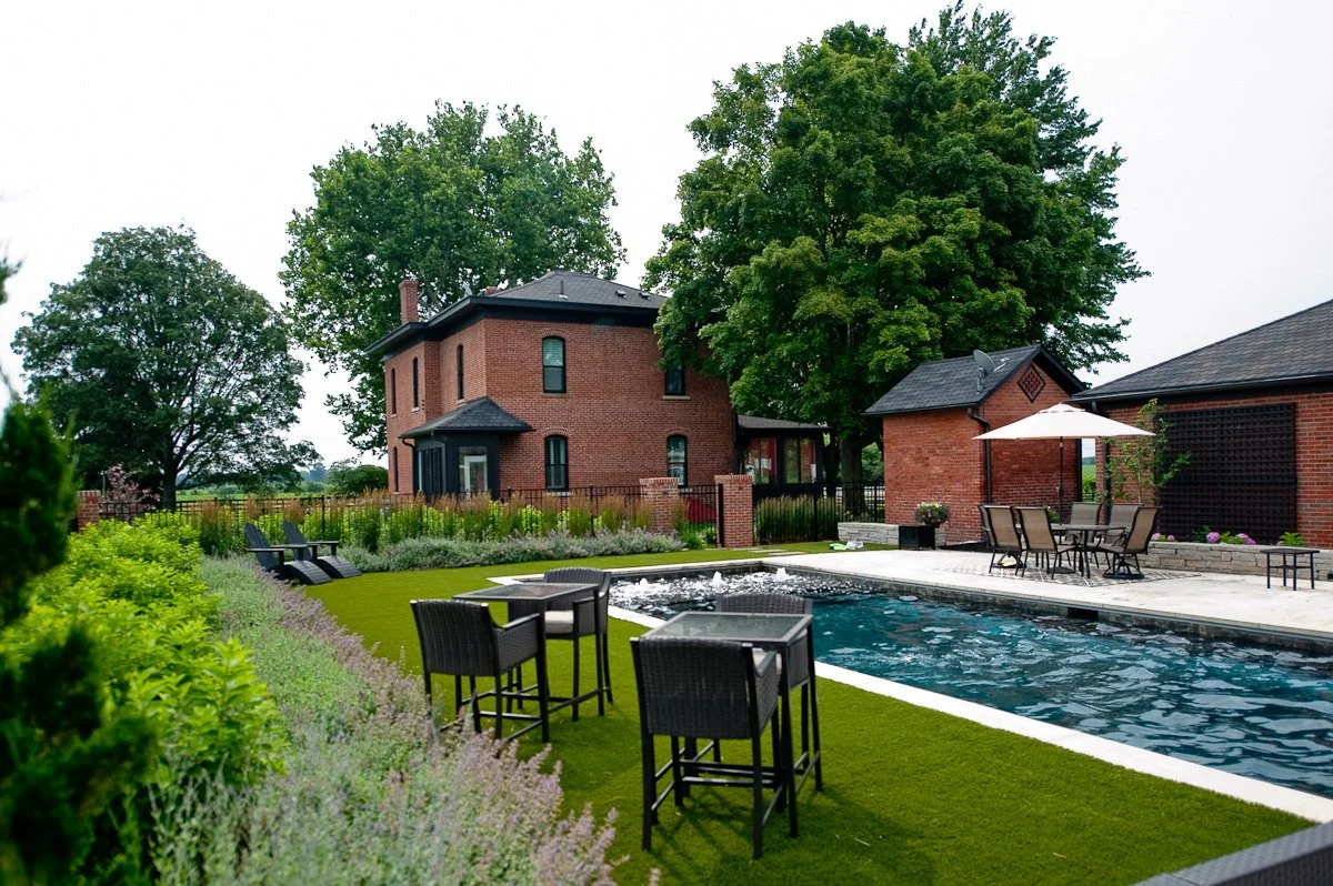 New formal lawn and pool with custom landscape design surrounding an historic farm.