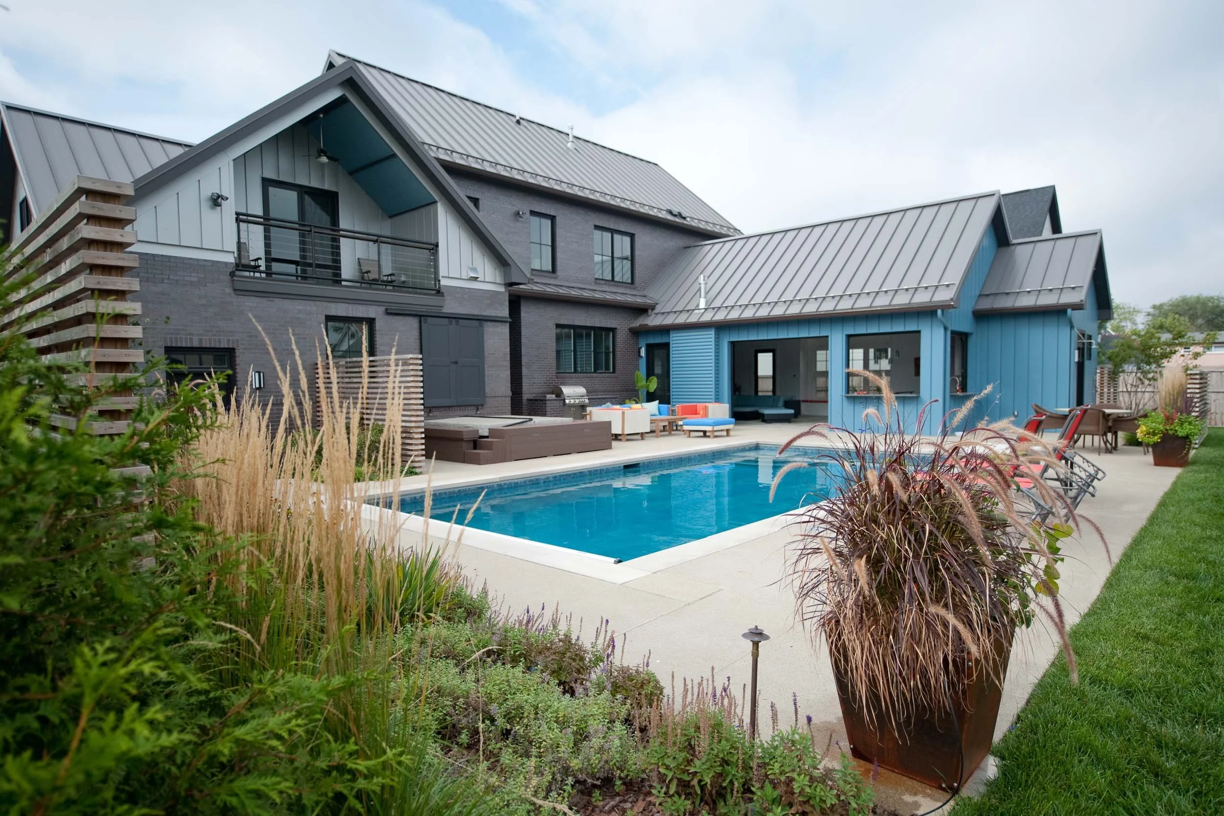 A large modern home featuring a new pool and hot tub. Custom landscape design surrounds the home.