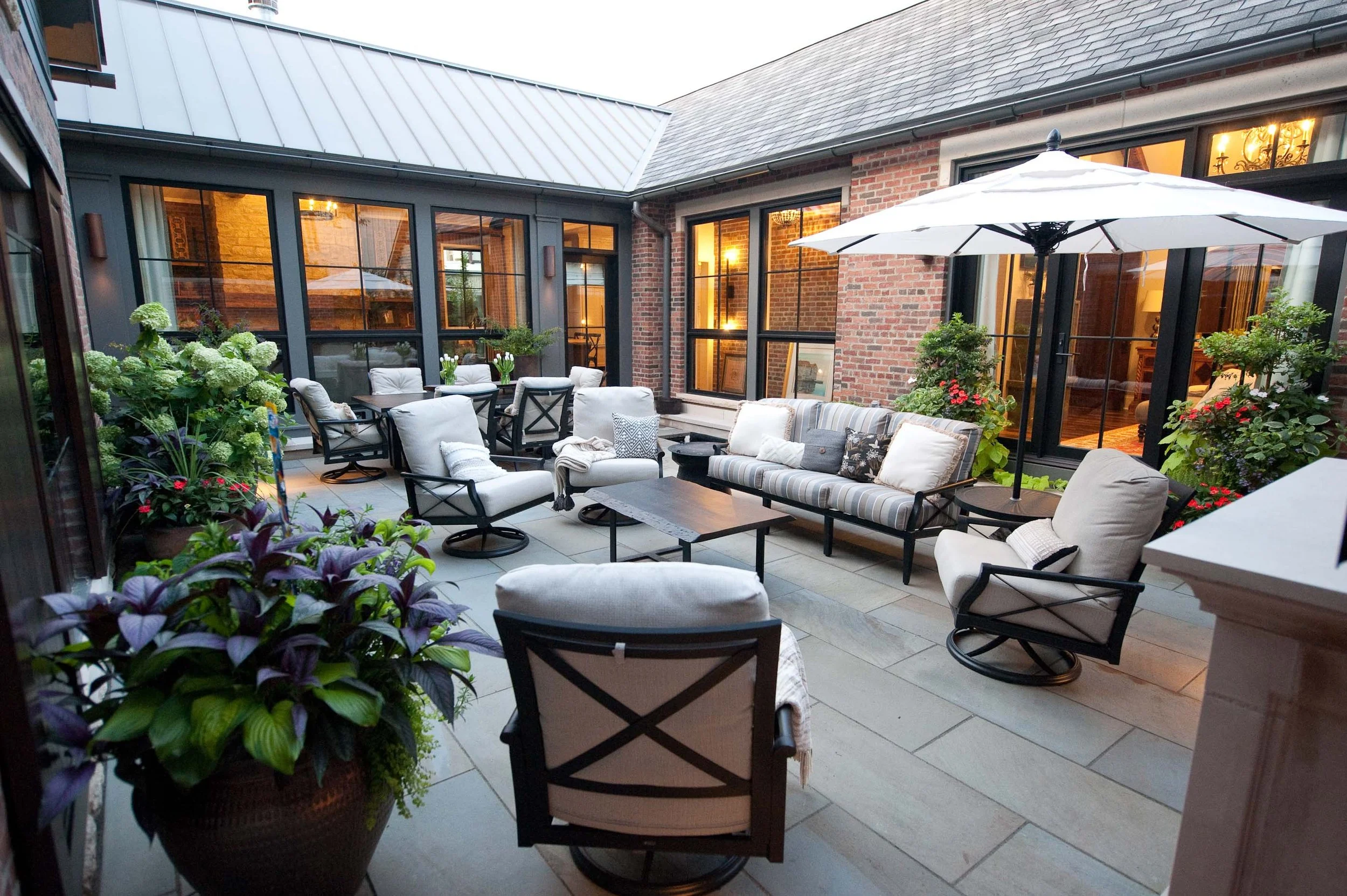 A gorgeous patio with seating and potted landscaping