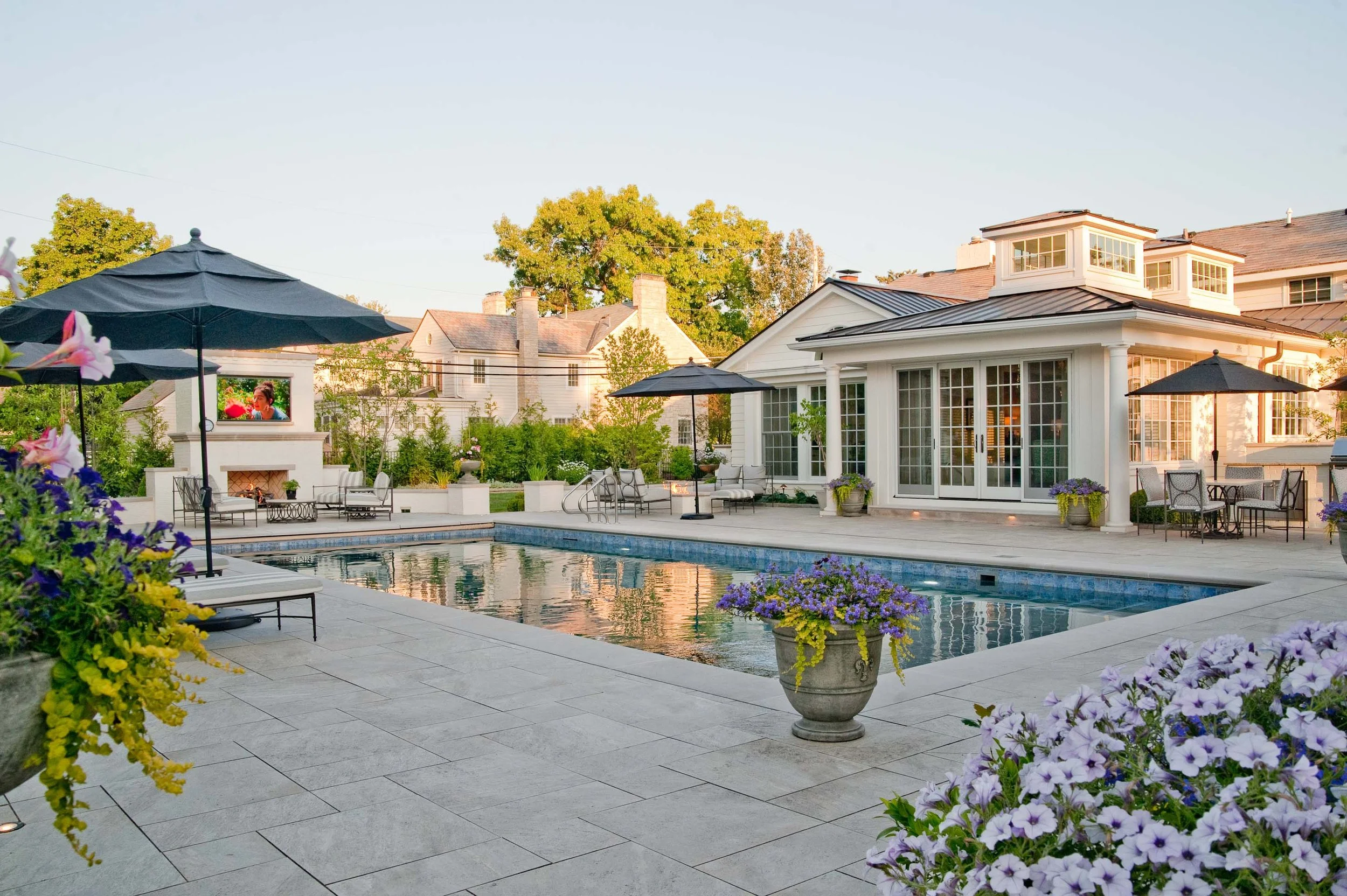 A beautiful new pool with a custom hearth, seating areas, and landscape design.