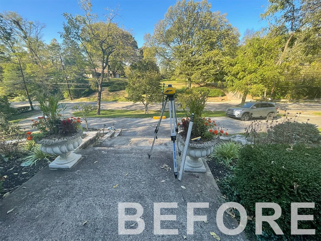 A photo taken from a porch with two large decorative planters filled with flowers, a surveying instrument on a tripod, and a street with trees and a parked gray SUV in the background, labeled 'BEFORE'.