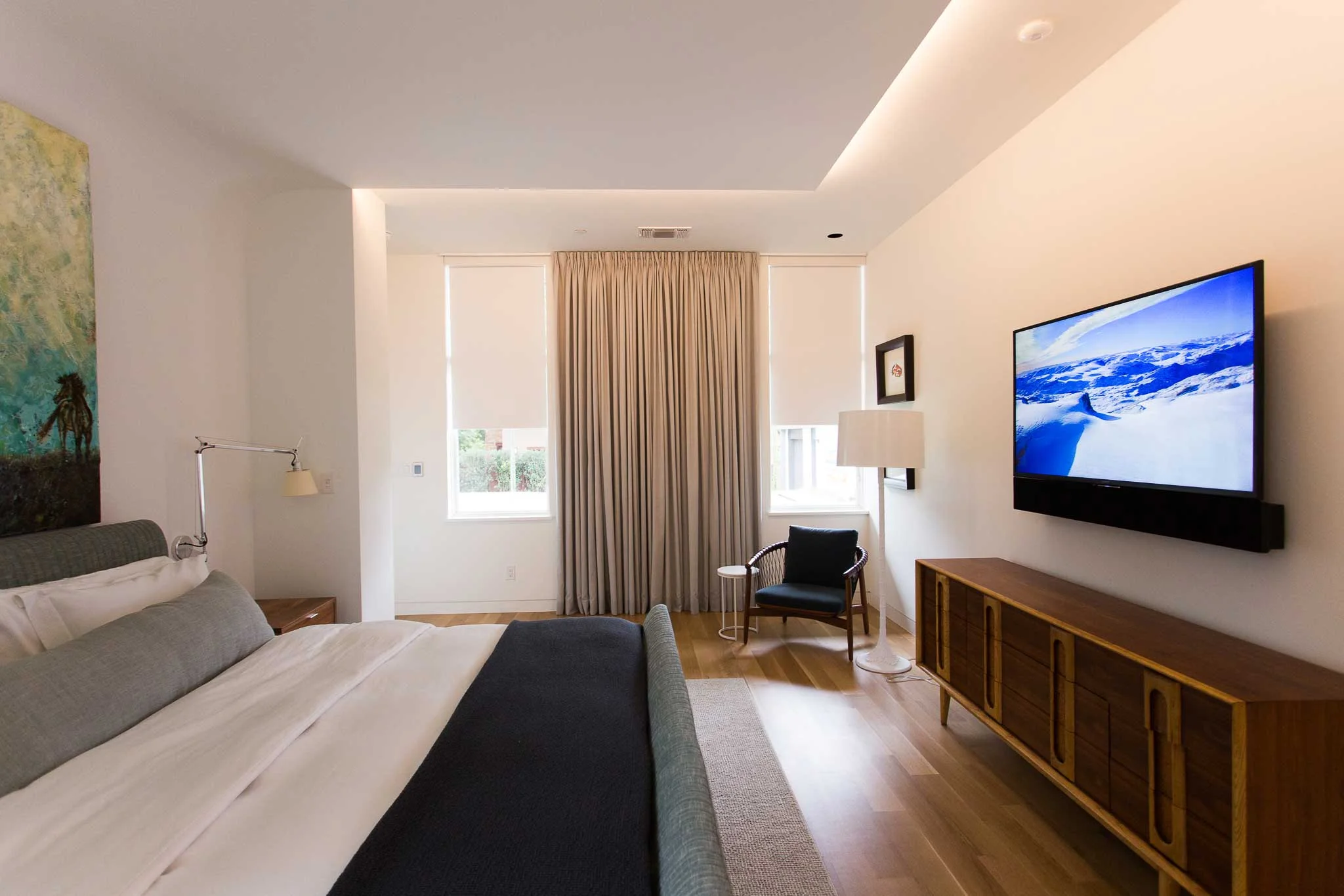 The crisp white fabric of the automated shades match the white walls that are a theme throughout the home