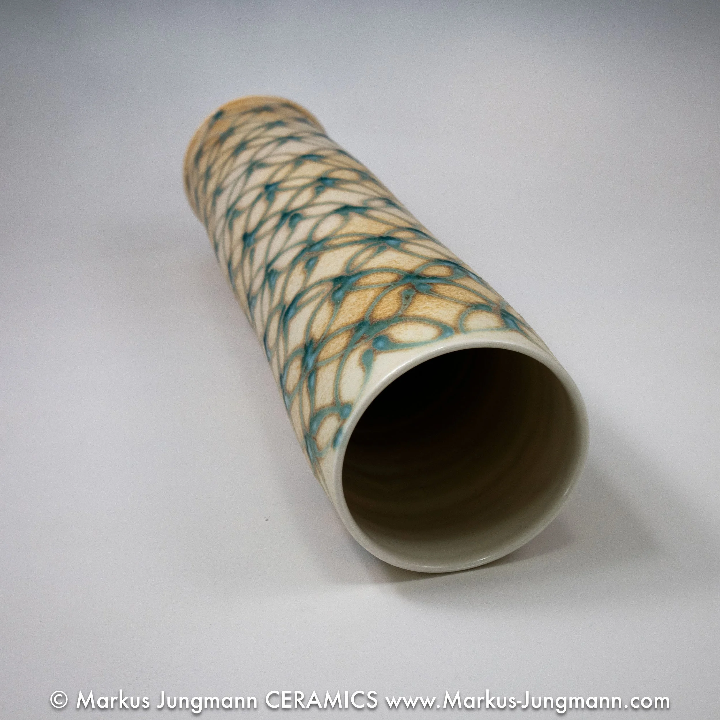 Tall porcelain vase with an interlocking-circle pattern in teal over a sandy ash-glaze ground, top, by Markus Jungmann