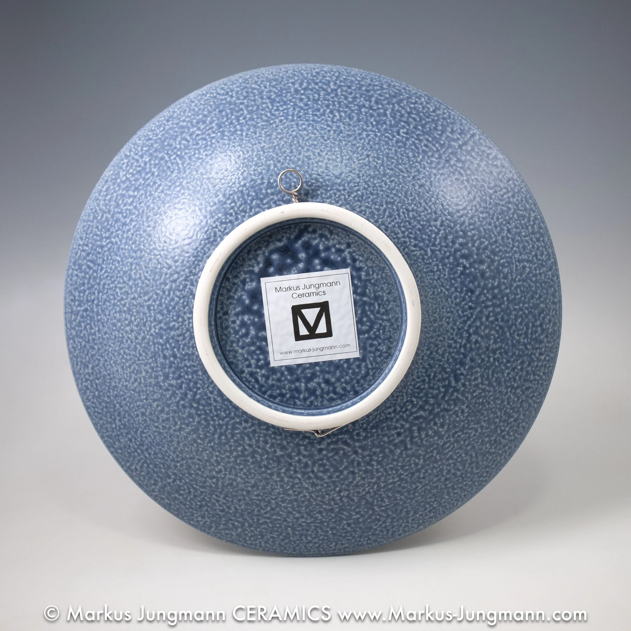 Porcelain bowl with a blue seigaiha wave pattern and iron-red accents on a speckled grey-blue ground, by Markus Jungmann. bottom view