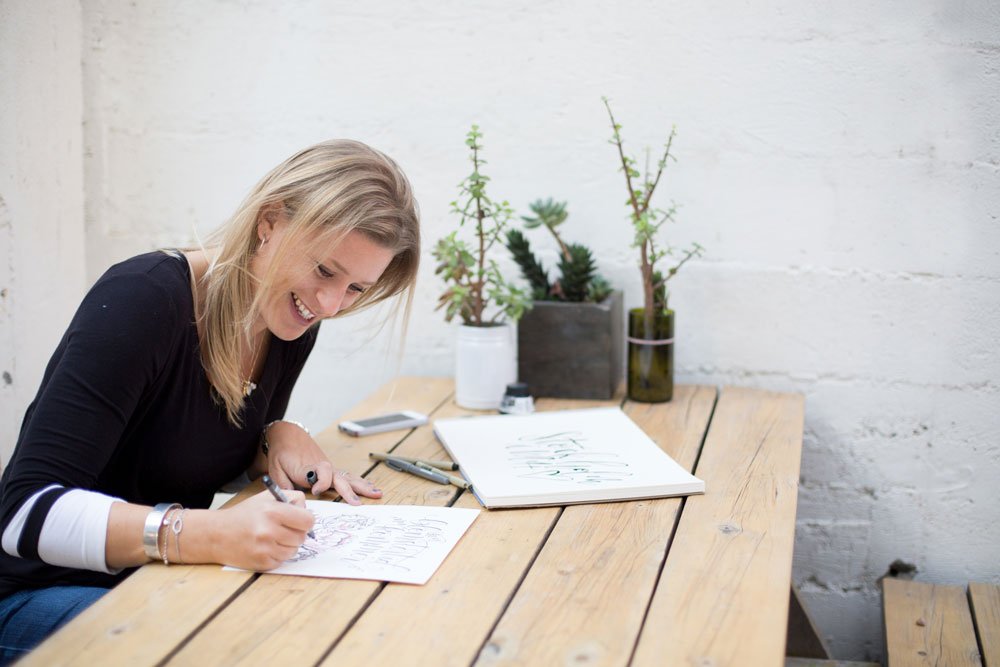 Kalligraf som sitter och skriver för hand