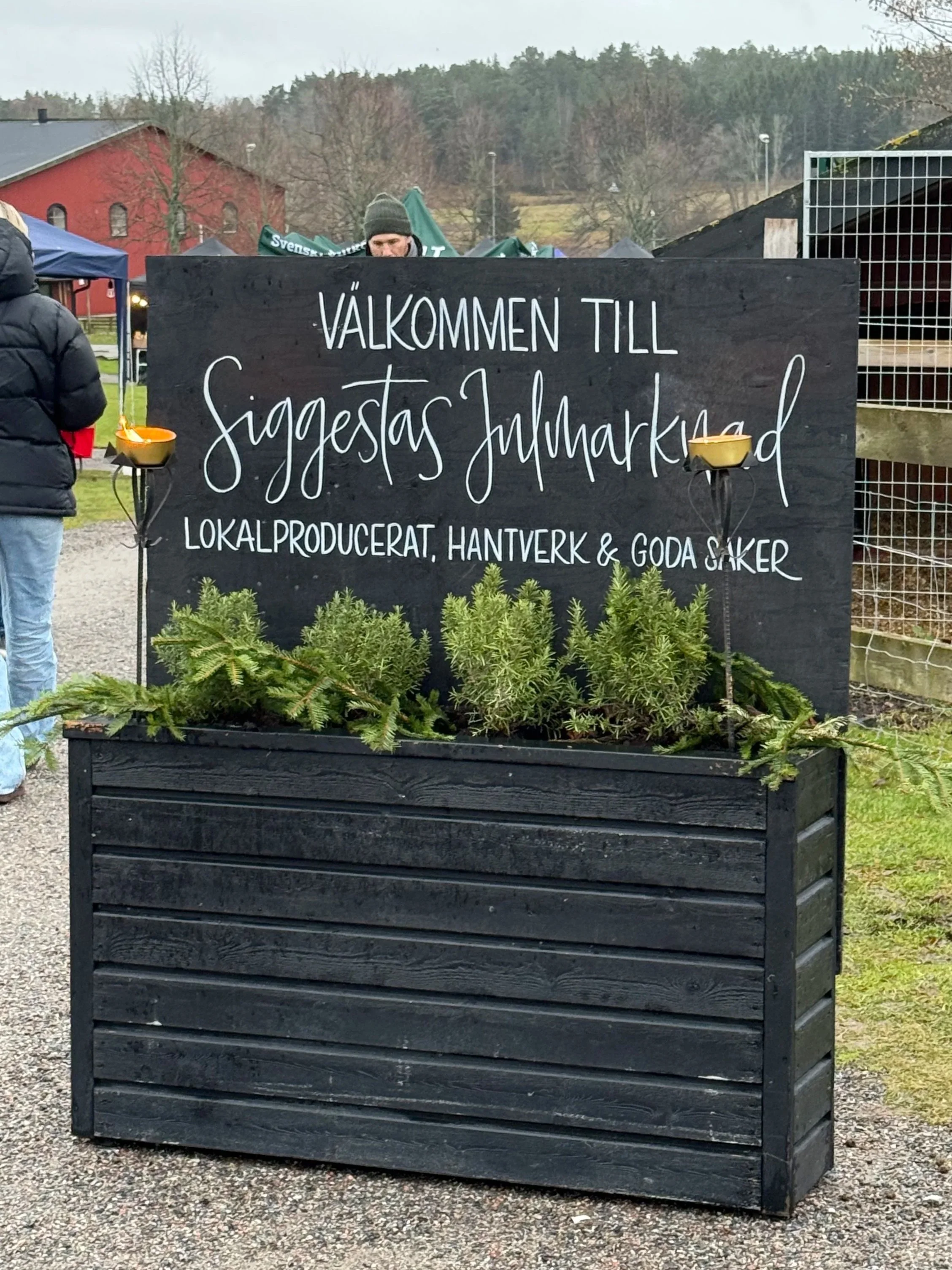 Svart skyltar med handmålad text och illustrationer i vitt och akrylfärger till julmarknad Siggesta Gård Värmdö Stockholm