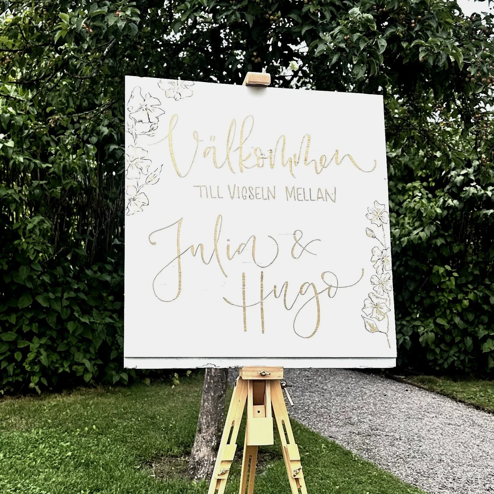 Välkomstskylt till bröllop handmålad i vitt och guld