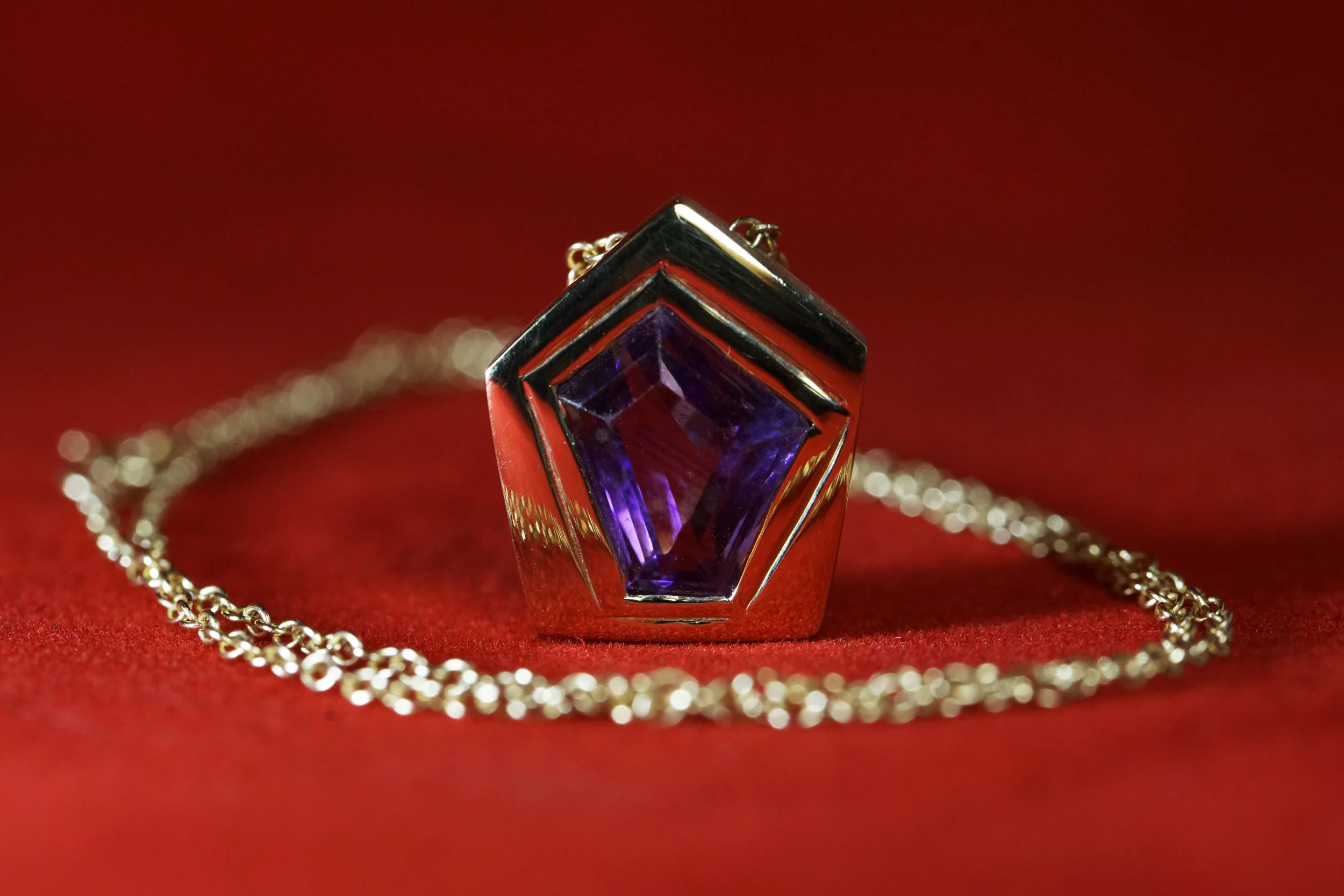  A uniquely cut amethyst set into a little 14k gold house. 