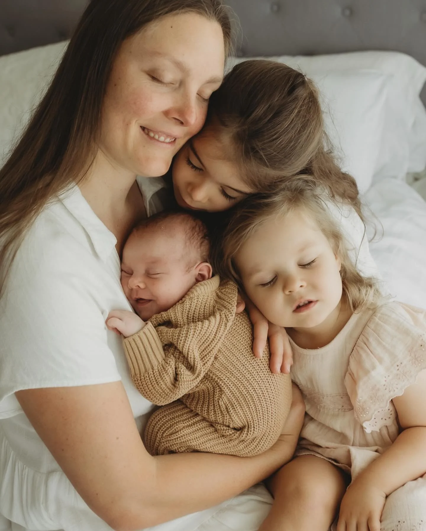 A glimpse into those first weeks, snuggled in between sheets and little hands wanting to hold him. Big sisters that are ready to help and eager to take on their new roles in life. 
 Did you catch George&rsquo;s precious smile in the first image? Snug
