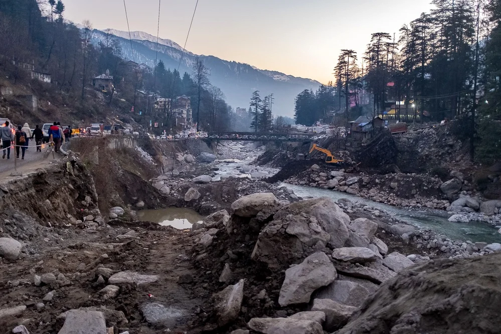 New Manali. The town is connected to the outside world by a road following the river down to the plains and further up into the Himalayas. The problem, as can be seen here, are landslides: Not only does the road crumble into the river, it is also bu…
