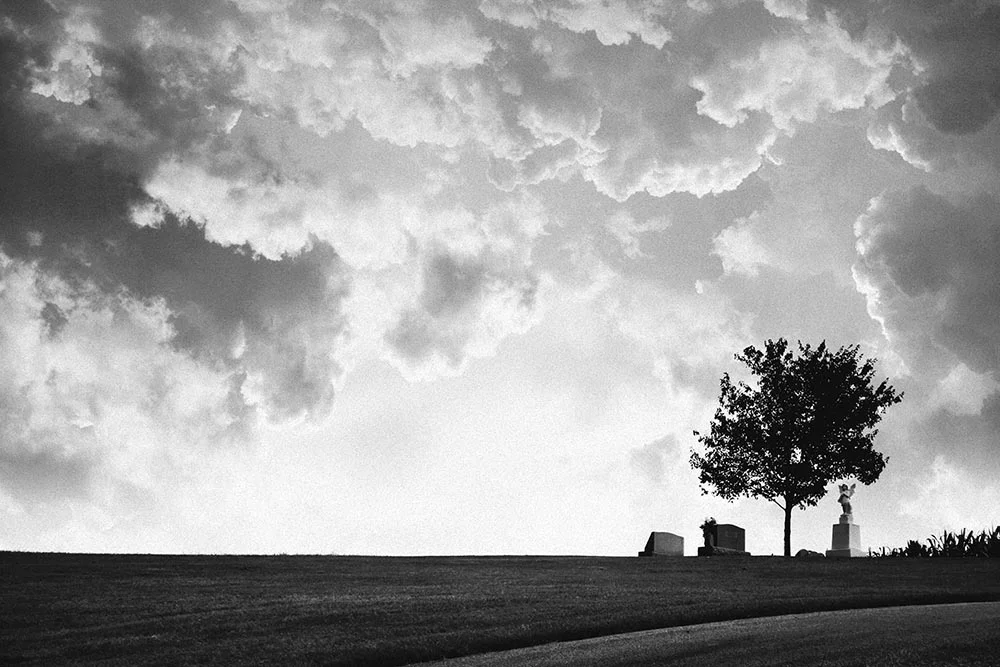 Black and white photo of a small cemetery on a country hillside.