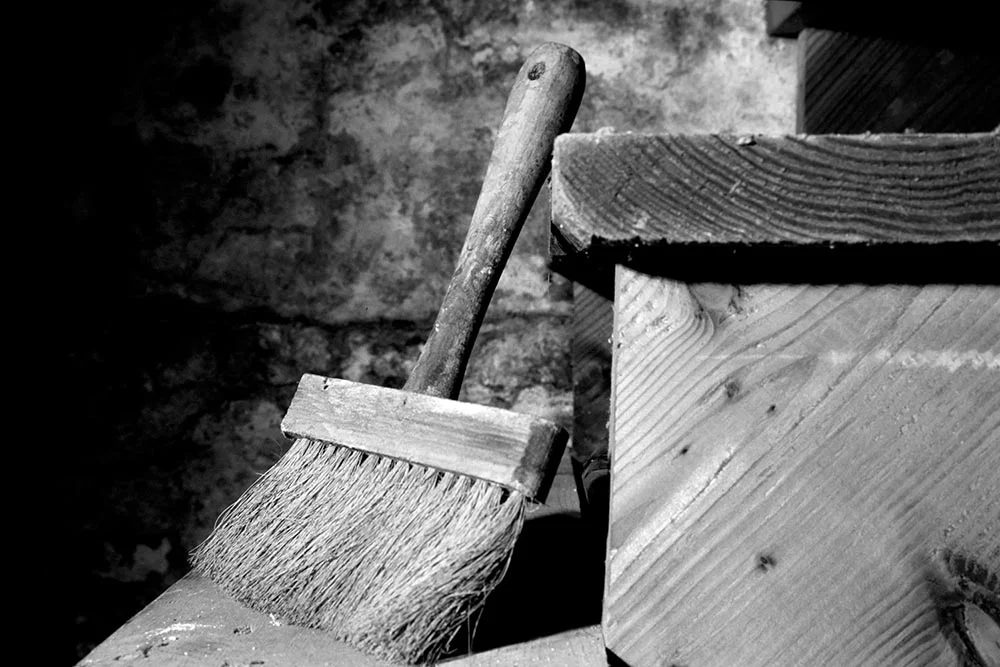 Black and white photograph of an antique wooden paintbrush.