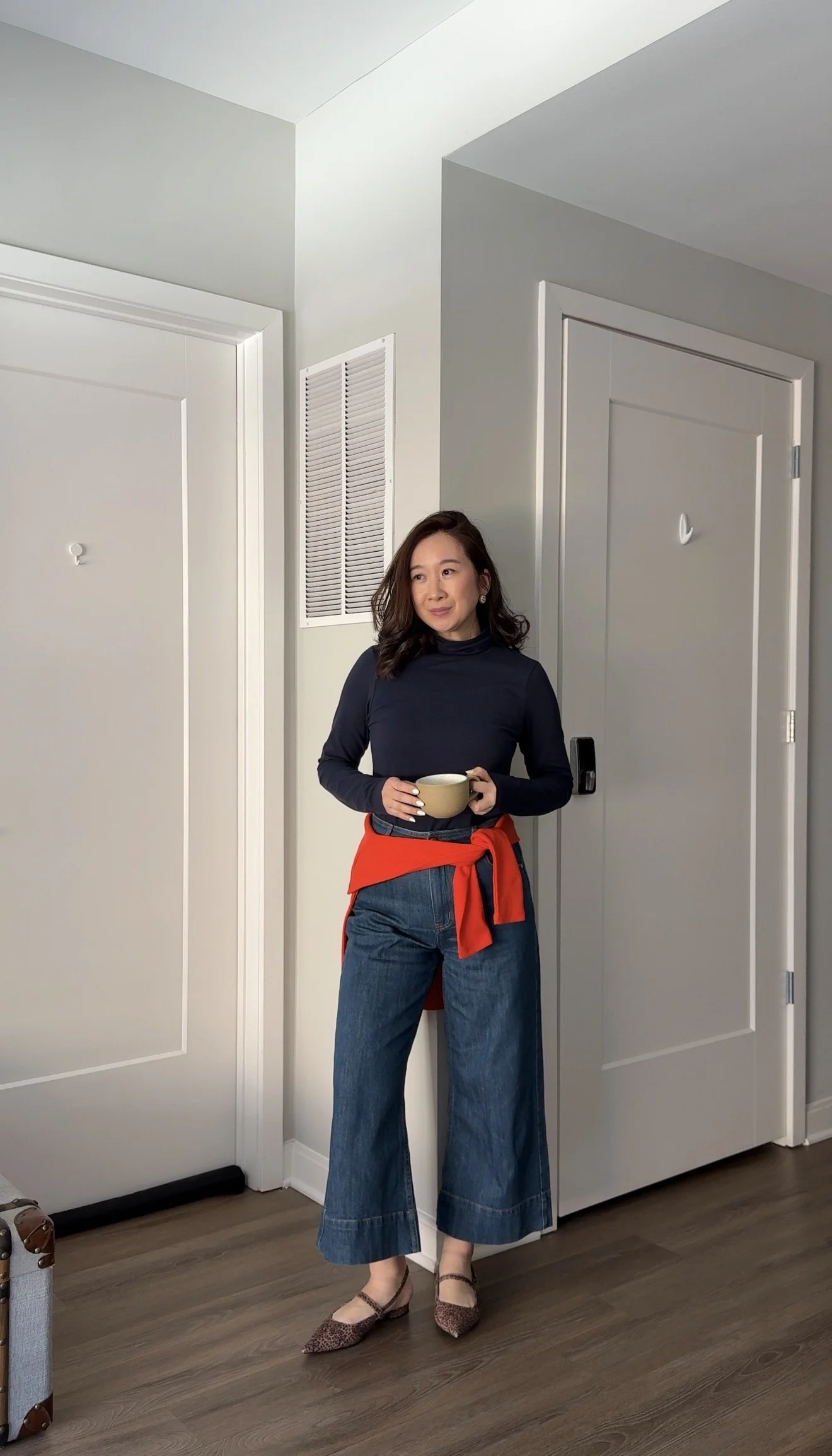 a petite woman wearing cropped wide-leg jeans made for shorter legs