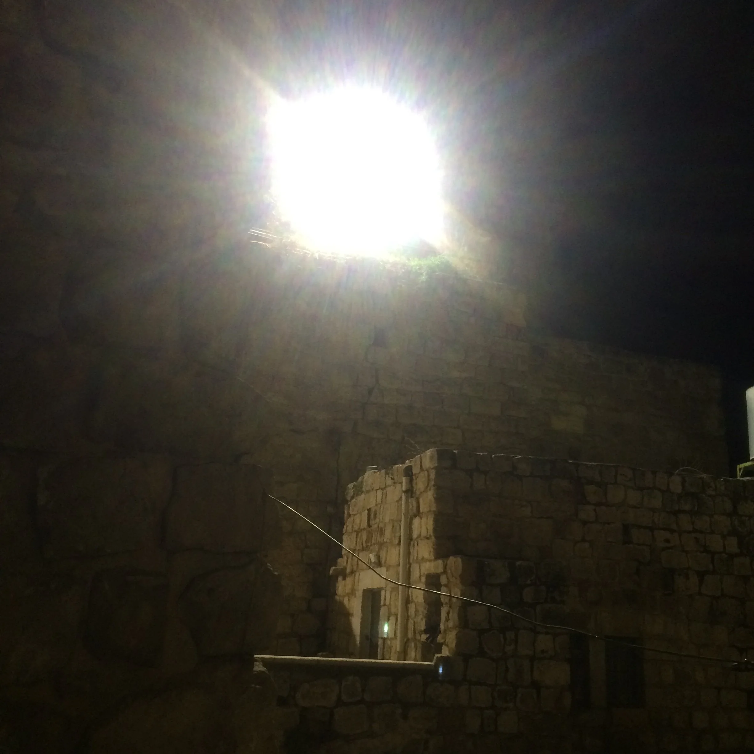  A picture from my bedroom in my host family’s home, which was illuminated every night by a spotlight from the outpost next door in Hebron. Photo by Michael Thomson 