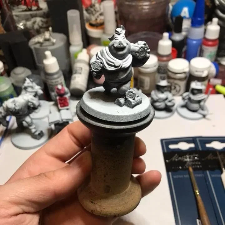I try to paint minis on some type of handle. This is a small wooden spool that I obtained from a craft store. Prescription bottles are also great handled. By putting our figures on a handle, it keeps our oily hands from smudging paint.